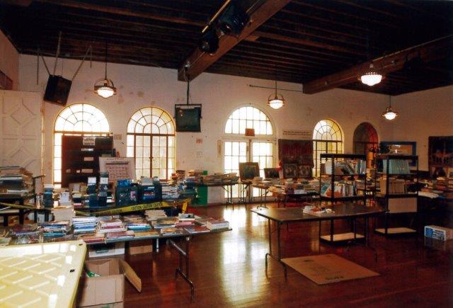 Before: Interior view of open office space facing north showing three arched window openings and one arched door entrance.